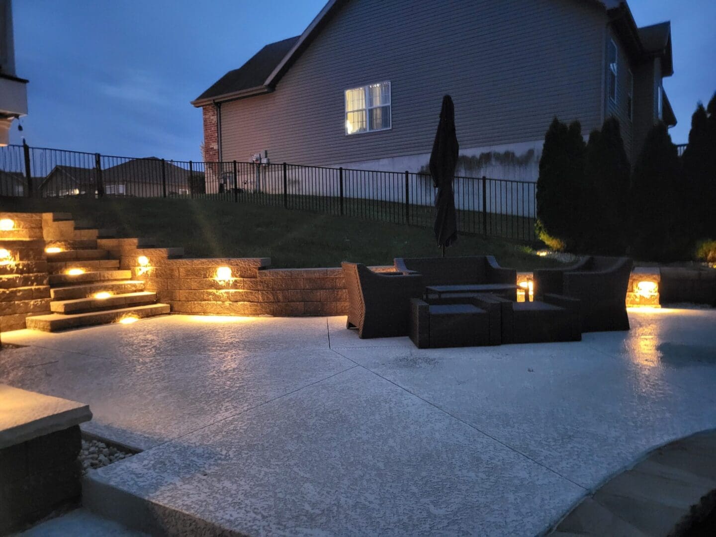 Cozy backyard patio at dusk with warm lighting and outdoor furniture.