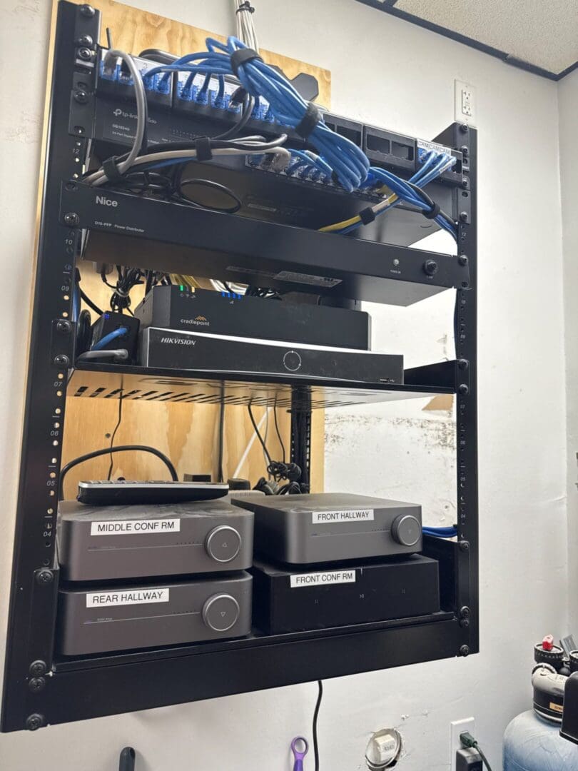 A metal rack holding audio equipment and cables.