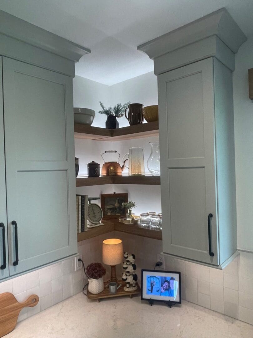 Cozy kitchen corner with wooden shelves and gray cabinets.