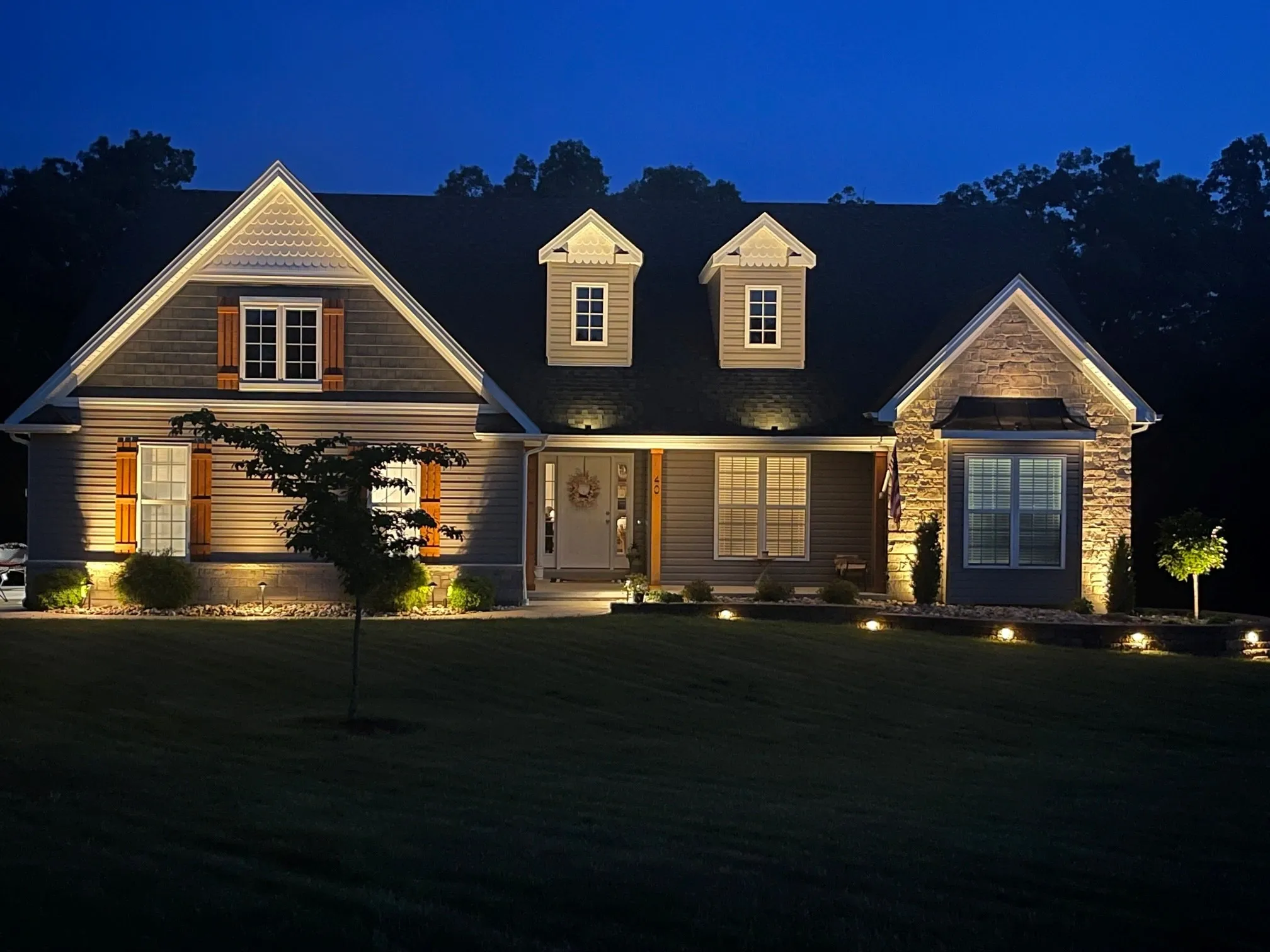 A cozy house warmly lit against the night sky.