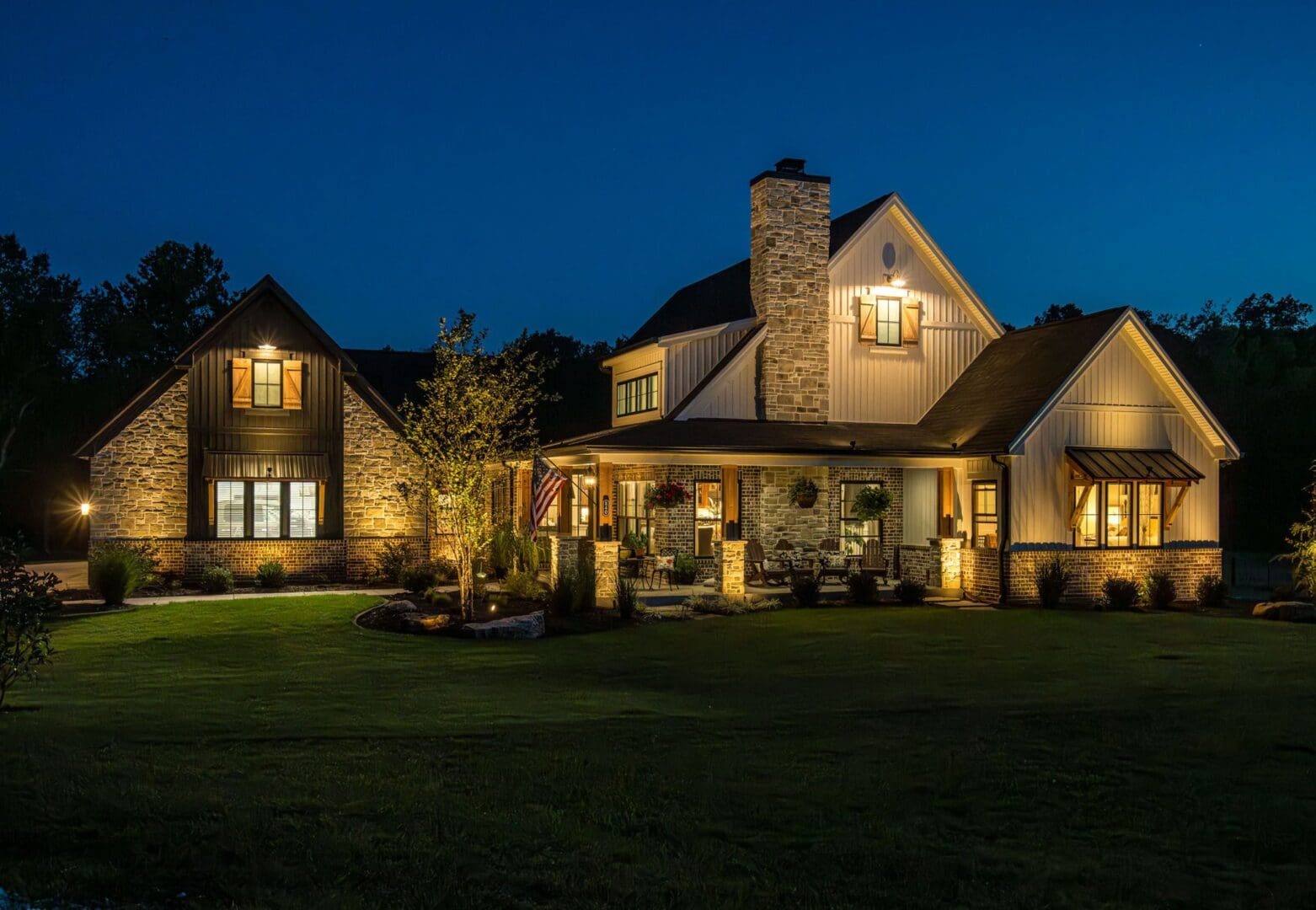 A beautifully lit house at night with warm exterior lighting.