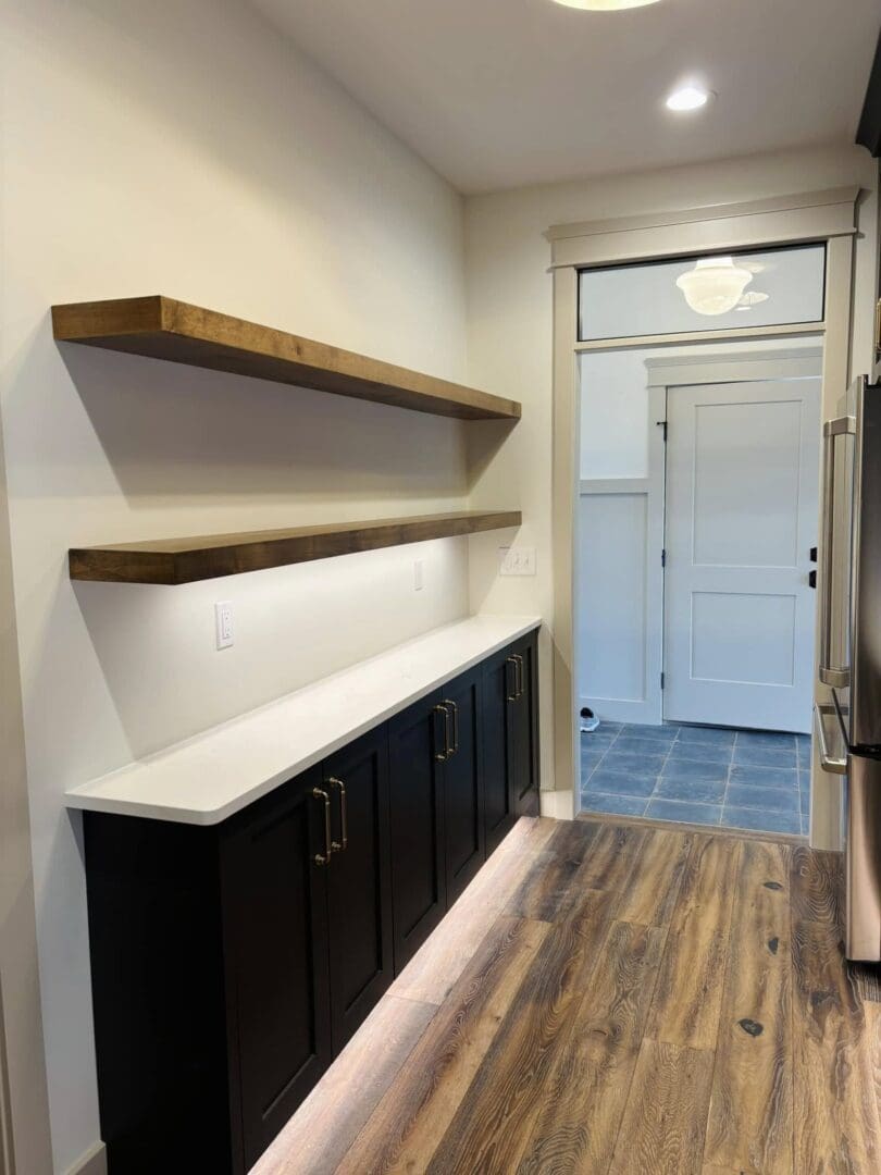 Modern hallway with dark cabinets, wooden shelves, and wood flooring.