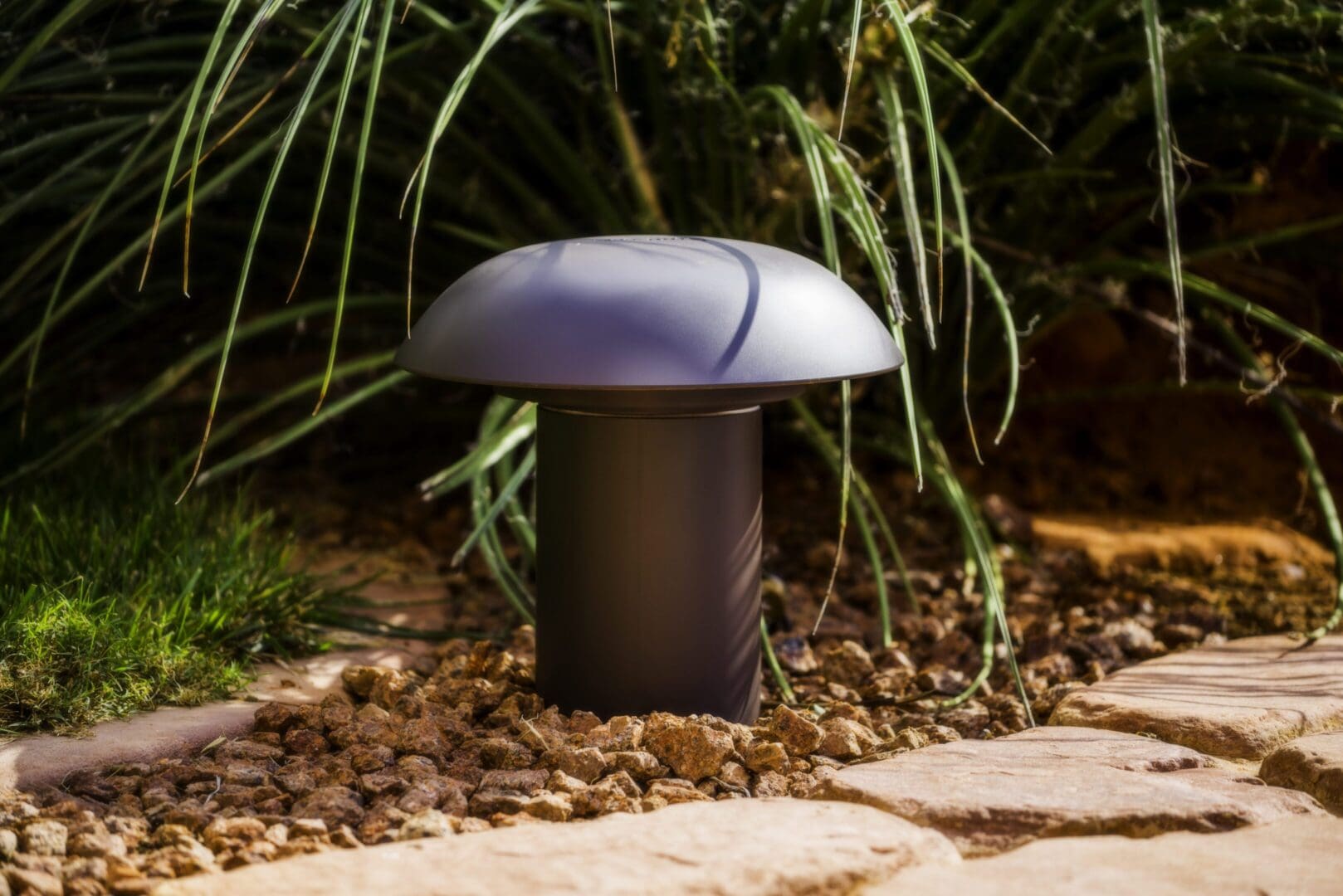 Outdoor mushroom-shaped garden lamp illuminating a pathway.